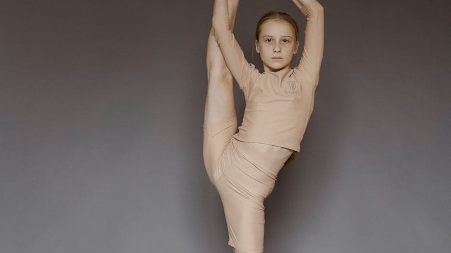 Athletic person performing a graceful yoga stretch outdoors during sunrise