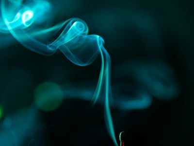 Incense smoke curling in front of a blue neon light source